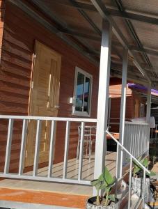 eine Veranda eines Hauses mit weißem Geländer in der Unterkunft Stay Ban Posai with Pool in Prakhon Chai