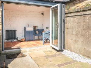 an open sliding glass door of a house with a patio at Archway Cottage in Matlock