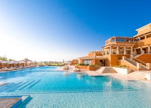 a swimming pool with blue water in a resort at The Cascades Golf Resort, Spa & Thalasso in Hurghada