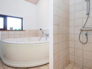 a bathroom with a tub and a shower at 6 person holiday home in Ulfborg in Thorsminde