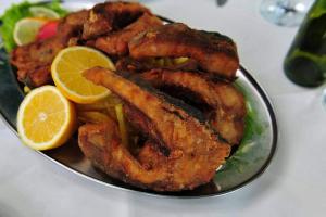 a plate of food with fried fish and lemon slices at Hotel Restaurant Aleksander in Korçë