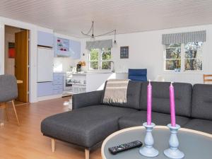 a living room with a couch and a table with two candles at 5 person holiday home in Glesborg in Glesborg