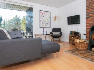 a living room with a couch and a fireplace at 5 person holiday home in Glesborg in Glesborg