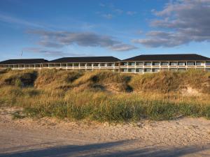 a building on top of a hill next to a beach at 4 person holiday home on a holiday park in Fan in Fanø