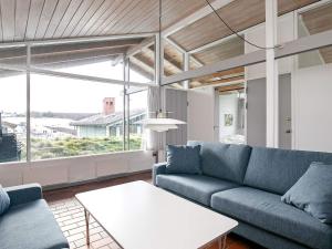a living room with a blue couch and a table at Vigsø Holiday Center- Type 7 in Hanstholm