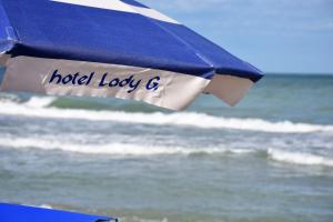 a blue and white umbrella on the beach at Hotel Lady G in Tortoreto Lido