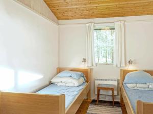 A bed or beds in a room at Three-Bedroom Holiday home in Aakirkeby 5