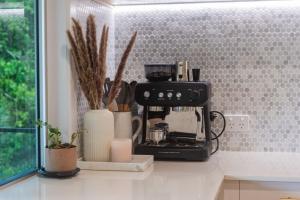 a black coffee maker on a counter in a kitchen at Airlie Abode in Airlie Beach