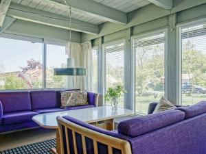 a living room with purple furniture and a table at 8 person holiday home in Allinge in Allinge