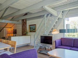 アリンエにある8 person holiday home in Allingeの紫色の家具と階段が備わるリビングルーム