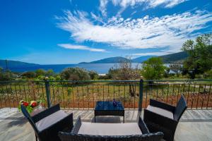 a patio with chairs and a table with a view of the water at Seaside Euphoria Kefalonia in Ayia Evfimia