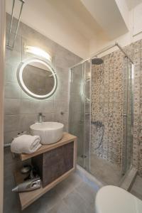 a bathroom with a sink and a glass shower at Seaside Euphoria Kefalonia in Ayia Evfimia