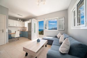 sala de estar con sofá azul y mesa en Seaside Euphoria Kefalonia, en Agia Efimia