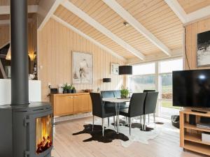 エーベルトフトにある6 person holiday home in Ebeltoftのダイニングルーム(暖炉、テーブル、椅子付)