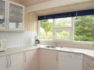 ヘンネ・ストランドにある6 person holiday home in Henneの白いキャビネット、シンク、窓付きのキッチン