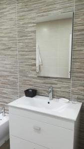 uma casa de banho com um lavatório branco e um espelho. em Casa Santa Cristina em Noya