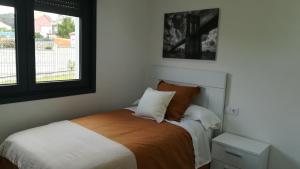 1 dormitorio con cama y ventana en Casa Santa Cristina, en Noia