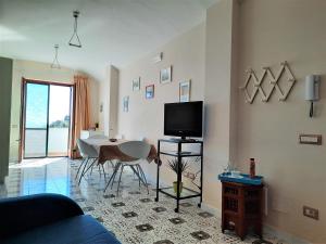a living room with a table and a tv in it at L'Arabesco Apartment in Amalfi