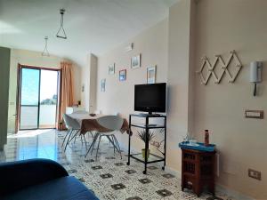sala de estar con mesa y TV. en L'Arabesco Apartment, en Amalfi