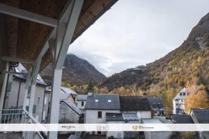 Vistas a una ciudad con montañas en el fondo en Appartement GAVARNIE Résidence Les 3 Cirques en Gèdre