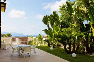 a patio with a table and chairs and plants at Alka Loft e Spa in Alcamo