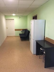 an office with a refrigerator and a desk and a chair at Hotel Rassvet in Saransk