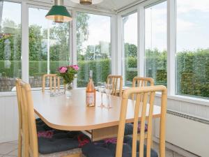 d'une salle à manger avec une table, des chaises et des fenêtres. dans l'établissement 4 person holiday home in Haderslev, à Haderslev