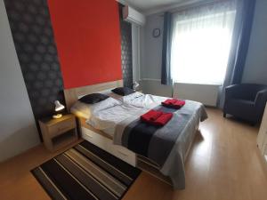 a bedroom with a bed with two red towels on it at Smart Szállás apartman in Miskolc in Miskolc
