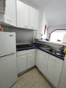 a small kitchen with white cabinets and a sink at Studio en Torrox Costa in Torrox Costa
