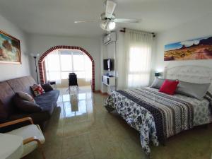 a bedroom with a bed and a couch at Studio en Torrox Costa in Torrox Costa +4 photos