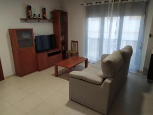 un salon avec un canapé et une télévision dans l'établissement Apartamento en Águilas, à Águilas