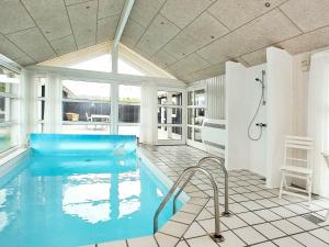 a bathroom with a swimming pool with a shower and a tub at 10 person holiday home in L kken in Grønhøj