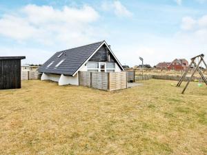 a house with a black roof and a playground at 6 person holiday home in Harbo re in Harboør
