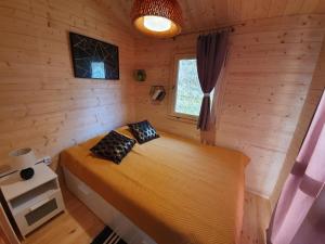 a bedroom with a bed in a wooden cabin at Domki Letniskowe w Burdągu in Jedwabno