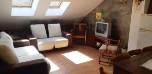 Una sala de estar con un sofá y un televisor. en Casa Antonio y Benina, en Sosas de Laciana