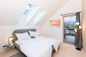 a bedroom with a bed and a large window at HIMMELBLAU - Design Apartment am Mondsee in Mondsee