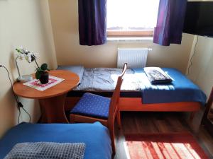 een kleine kamer met een tafel en een bed en een kleine tafel en stoel bij Apartament Wakacyjny in Rewal