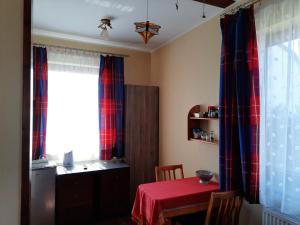 een kamer met een tafel en een raam met een rode tafellaken bij Apartament Wakacyjny in Rewal