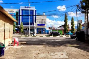 eine leere Straße mit einem Gebäude und einem roten Stuhl in der Unterkunft Hotel Rosichan Bau Bau Mitra RedDoorz in Baubau