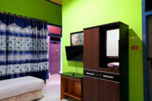 a bedroom with a bed and a tv in a room at Hotel Rosichan Bau Bau Mitra RedDoorz in Baubau