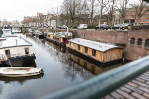 格罗宁根Wellnessboat De Michiel de Ruyter的一群船停靠在运河上
