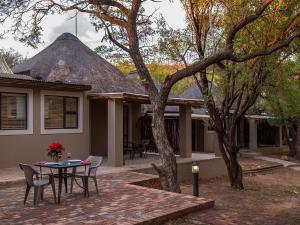 a patio with a table and chairs in front of a house at Mabalingwe Elephant Lodge 267-7 & 267-8 in Mabula