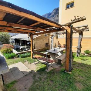 a wooden pergola with a picnic table and a bench at La Pergola by Quokka 360 - for mountain sports enthusiasts in Lavorgo