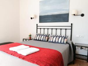 a bedroom with a bed with a red blanket at Casa Consell Gran Via, Guest House in Barcelona