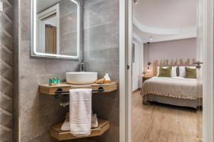 a bathroom with a sink and a bed and a mirror at Linda Boutique Hotel in Marbella