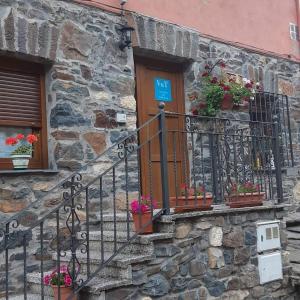 Un edificio de piedra con plantas en macetas en un balcón en Casa Antonio y Benina, en Sosas de Laciana