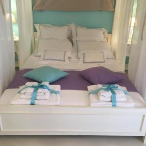 Una cama blanca con toallas y almohadas. en Chiqui luxury apartments, en Centro histórico de Alónnisos