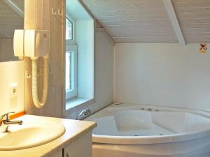 ein Badezimmer mit einer Badewanne und einem Waschbecken in der Unterkunft 6 person holiday home in Otterndorf in Otterndorf