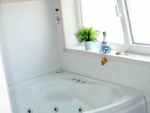 eine weiße Badewanne im Bad mit Fenster in der Unterkunft 5 person holiday home in Otterndorf in Otterndorf