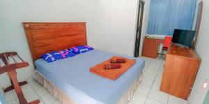 Un pat sau paturi într-o cameră la Hotel Rajawali Mitra RedDoorz